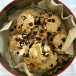 a tin of chocolate chip cookies with chocolate chips and nuts